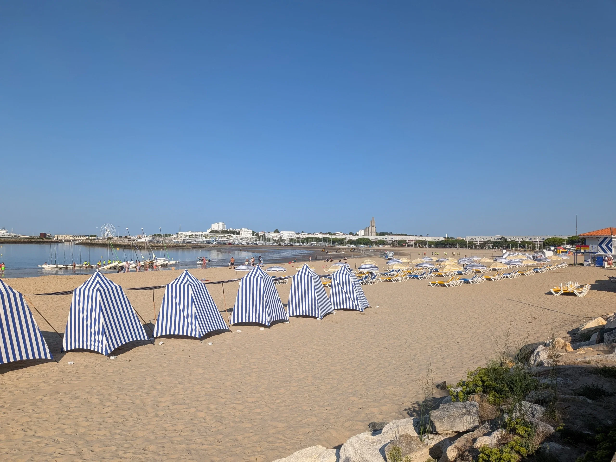 Tentes de plage rayées bleu et blanc sur le sable de Royan, face à la baie et au front de mer.